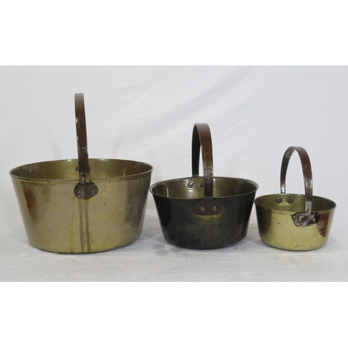 97 - Three round brass pots of graduating sizes with shaped handles