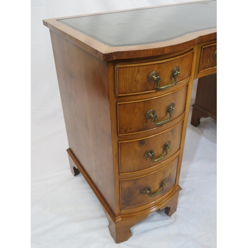 145 - Edwardian style serpentine fronted yew pedestal desk with shaped drawers, brass drop handles, on bra... 