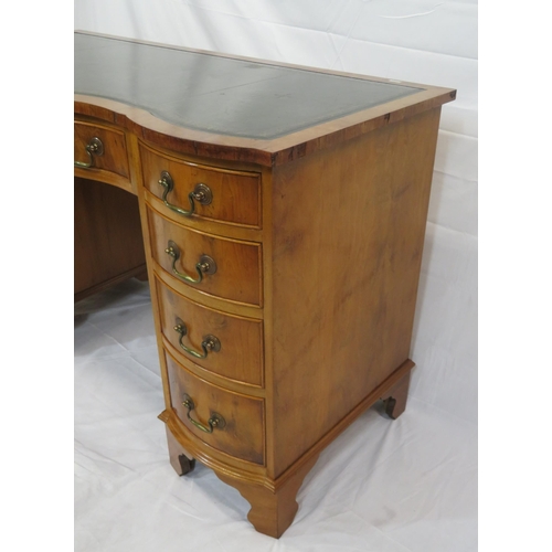 145 - Edwardian style serpentine fronted yew pedestal desk with shaped drawers, brass drop handles, on bra... 