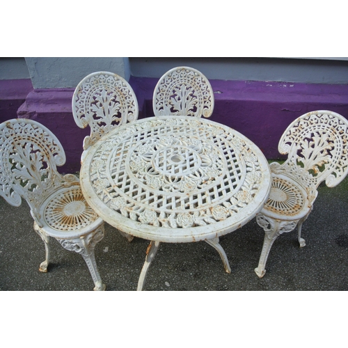 172 - Ornate cast iron four piece patio or garden suite - round table with rose decoration & four chairs w... 