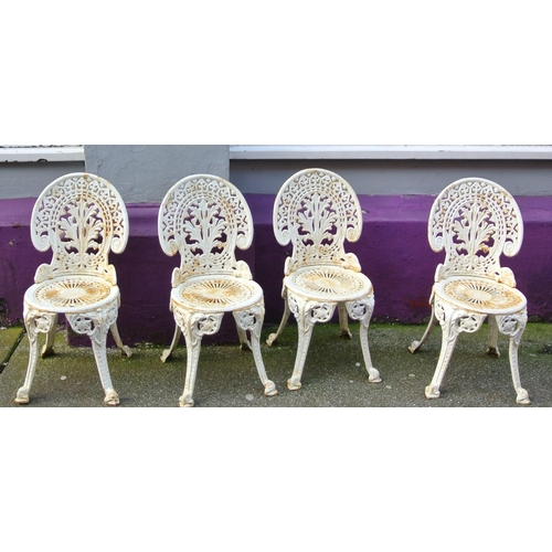 172 - Ornate cast iron four piece patio or garden suite - round table with rose decoration & four chairs w... 