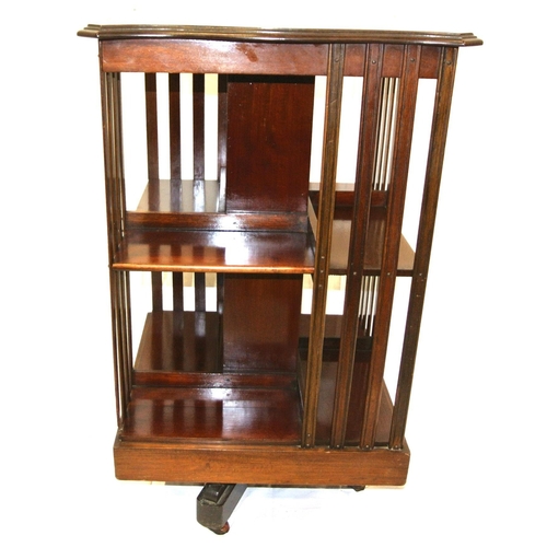 241 - Edwardian mahogany revolving bookcase with serpentine top, reeded rails, on quadrapod