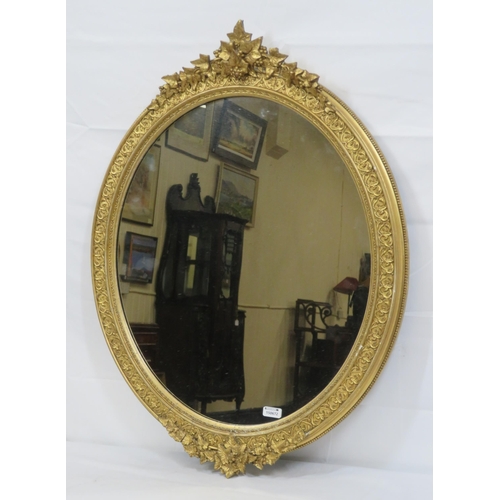 322 - Ornate oval gilt framed wall mirror with ornate foliate & scroll decoration