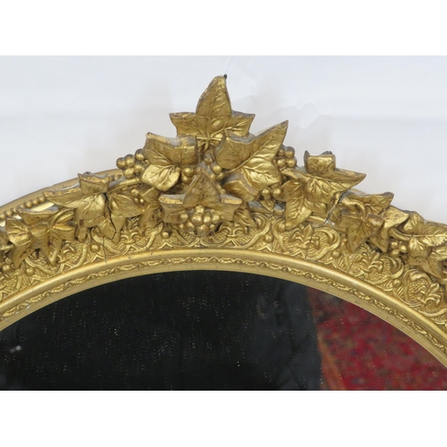 322 - Ornate oval gilt framed wall mirror with ornate foliate & scroll decoration