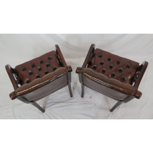 354 - Pair of Regency design open armchairs with buttoned leather upholstery, scroll arms, on sabre legs