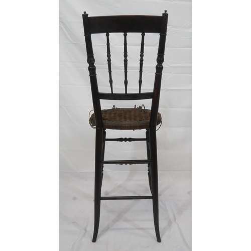 357 - Arts & Crafts high chair with turned spindles, wicker seat, turned legs with stretchers