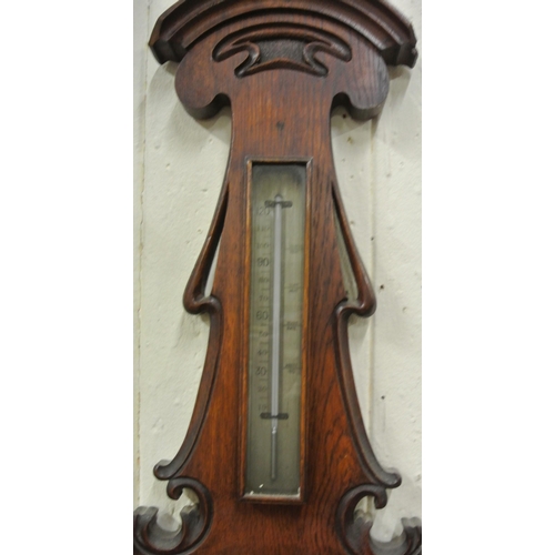 217 - Edwardian oak wheel barometer with brass framed dial, thermometer and scroll carving