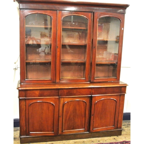 285 - Victorian mahogany triple bookcase with shaped frieze, glazed doors with shelved interior, drawers u... 