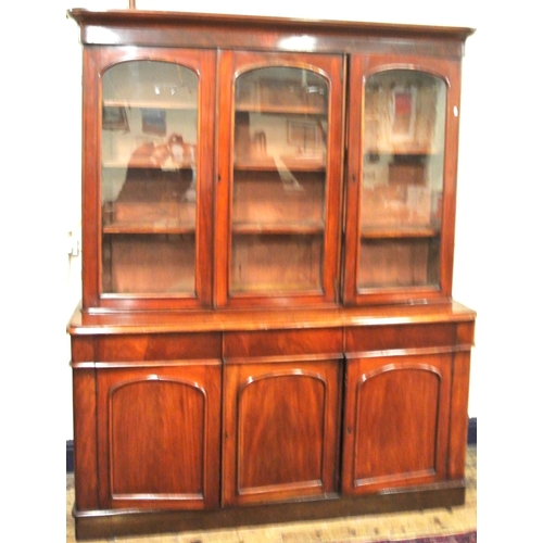 285 - Victorian mahogany triple bookcase with shaped frieze, glazed doors with shelved interior, drawers u... 