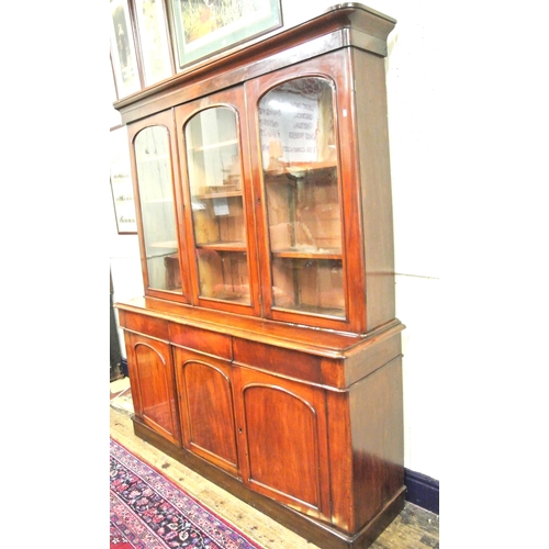 285 - Victorian mahogany triple bookcase with shaped frieze, glazed doors with shelved interior, drawers u... 