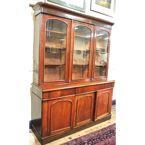 285 - Victorian mahogany triple bookcase with shaped frieze, glazed doors with shelved interior, drawers u... 