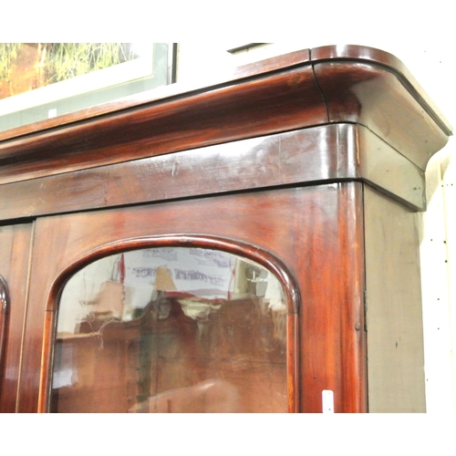 285 - Victorian mahogany triple bookcase with shaped frieze, glazed doors with shelved interior, drawers u... 