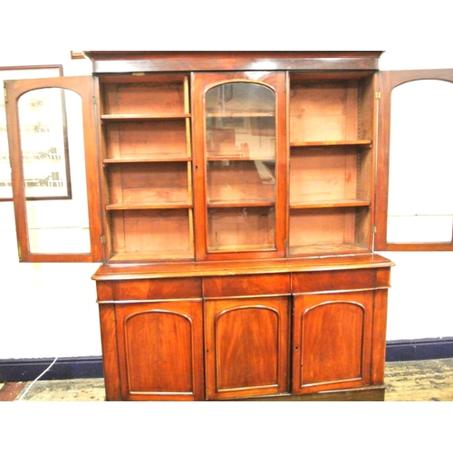 285 - Victorian mahogany triple bookcase with shaped frieze, glazed doors with shelved interior, drawers u... 