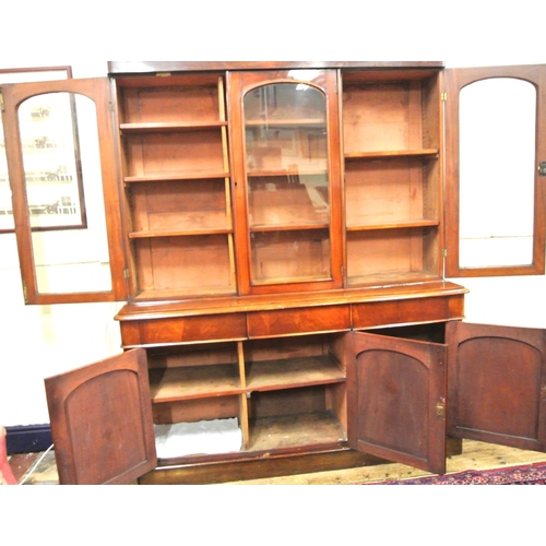 285 - Victorian mahogany triple bookcase with shaped frieze, glazed doors with shelved interior, drawers u... 