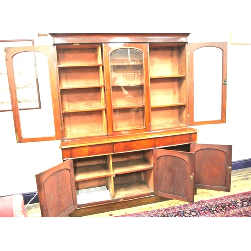 285 - Victorian mahogany triple bookcase with shaped frieze, glazed doors with shelved interior, drawers u... 