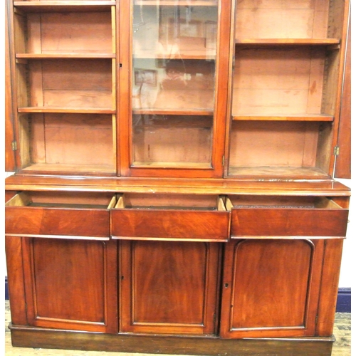 285 - Victorian mahogany triple bookcase with shaped frieze, glazed doors with shelved interior, drawers u... 