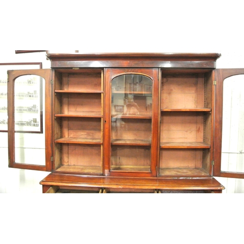 285 - Victorian mahogany triple bookcase with shaped frieze, glazed doors with shelved interior, drawers u... 