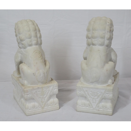 288 - Pair of Oriental carved marble Foo dogs with with oblong foliate decorated bases