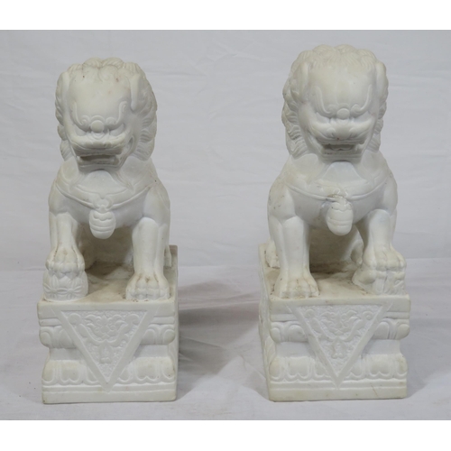 288 - Pair of Oriental carved marble Foo dogs with with oblong foliate decorated bases