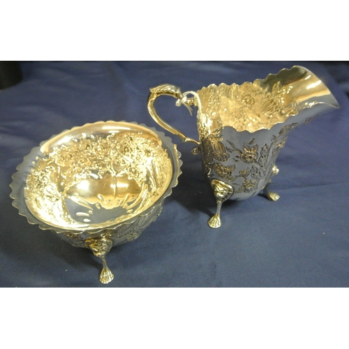 217 - Irish silver cream jug and matching sugar bowl with wavy rims, leaf capped scroll handle, profusely ... 