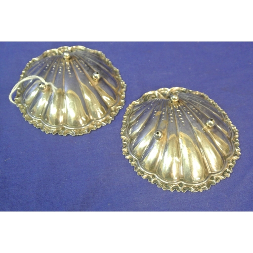 27 - Pair of silver plated shell shaped bon-bon dishes with scroll rims, each on 3 ball feet