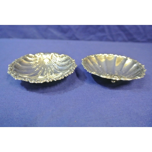 27 - Pair of silver plated shell shaped bon-bon dishes with scroll rims, each on 3 ball feet