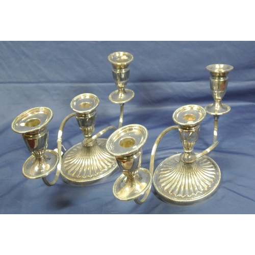 16 - Pair of silver plated candleabrae with shaped arms and sconces on oval spreading bases