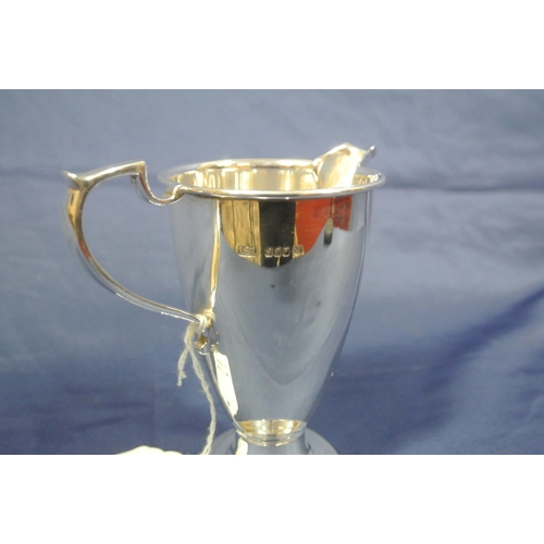 237 - Irish silver cream jug of round tapering form with wire rim, capped shaped handle, on round stepped ... 