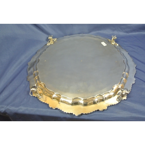 64 - Large Sheffield silver serving tray with raised gadroon and scroll border, on 3 cast claw-on-ball fe... 