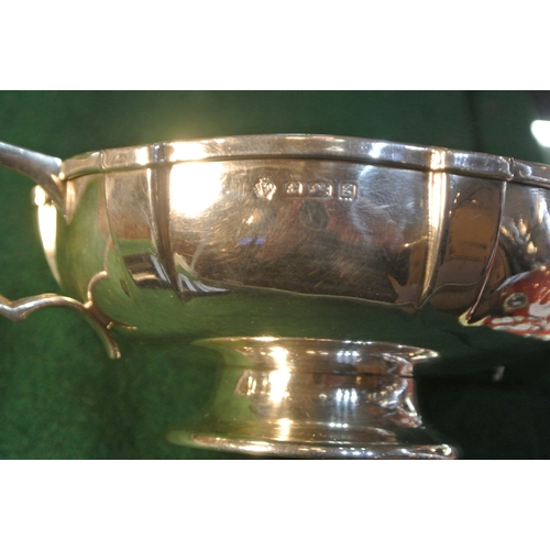 73 - Birmingham silver porringer with shaped panelled sides and handles, on raised round foot. H 5cm X L ... 