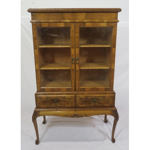 140 - Edwardian design walnut bookcase with foliate decoration, glazed doors, shelved interior, two drawer... 