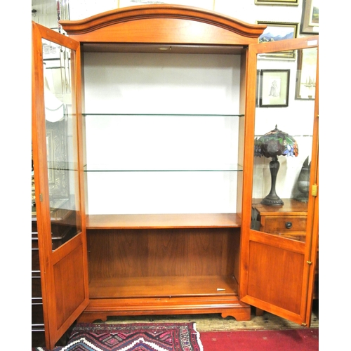 155 - Yew bookcase or display cabinet with serpentine top, glazed doors and shelving, on bracket feet