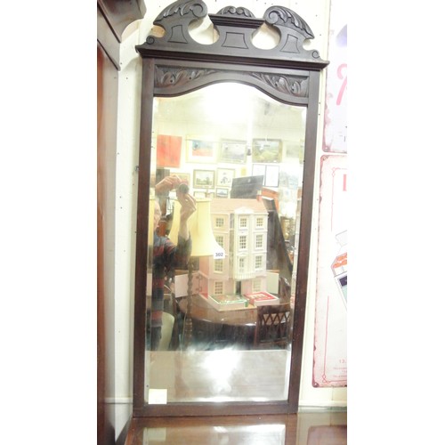 302 - Mahogany framed bevelled glass wall mirror with shaped pediment