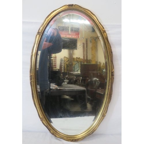 188 - Oval framed bevelled glass wall mirror with ornate gilt frame