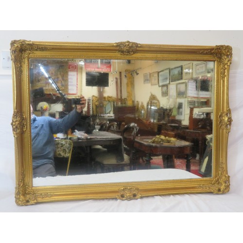 142 - Victorian design gilt framed wall mirror with scroll & foliate decoration