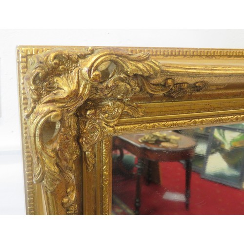 142 - Victorian design gilt framed wall mirror with scroll & foliate decoration