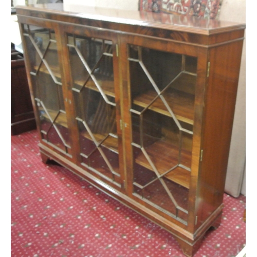 105 - Edwardian style triple bookcase with astragal glazed doors, shelved interior, on bracket feet