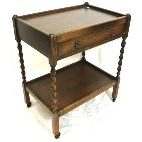 111 - Edwardian style oak two tier trolley with frieze drawer, barleytwist columns, & castors