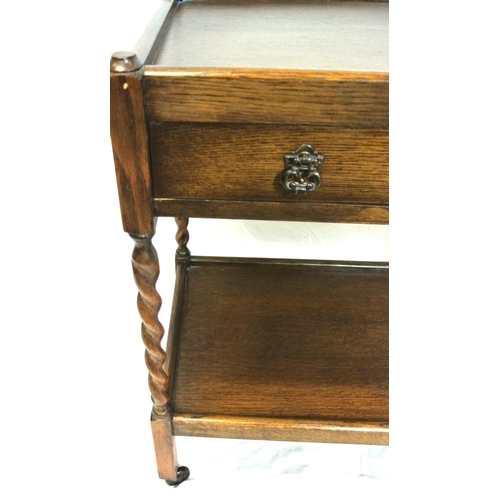 111 - Edwardian style oak two tier trolley with frieze drawer, barleytwist columns, & castors