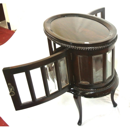 175 - Butlers oval drinks cabinet with detachable tray, bevelled glazed panels, brass drop handle, on cabr... 