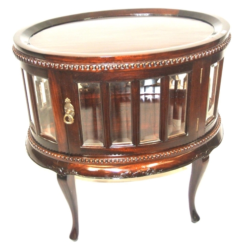 175 - Butlers oval drinks cabinet with detachable tray, bevelled glazed panels, brass drop handle, on cabr... 