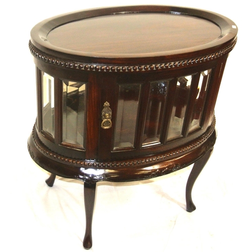 175 - Butlers oval drinks cabinet with detachable tray, bevelled glazed panels, brass drop handle, on cabr... 
