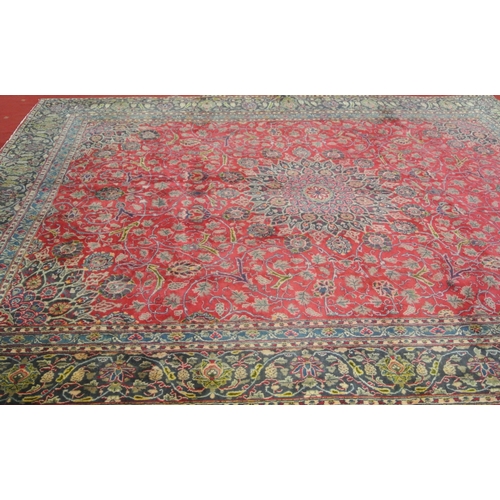 147 - Large red ground Persian Kashan carpet with traditional lozenge medallion design. 345x250cm