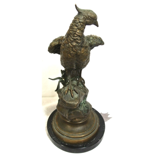 228 - Ornate bronzed figure of a falcon on a rock, on round stepped base