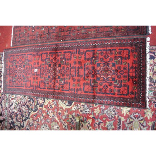 261 - Two rich red ground full pile Afghan Tubi runners with bespoke Bokhara design. 150 x54 cm each