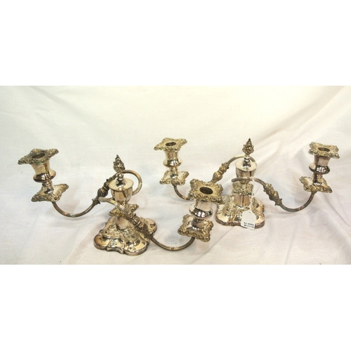 15 - Pair of silverplated candleabrae with shaped arms and foliate decorated sconces and shaped bases