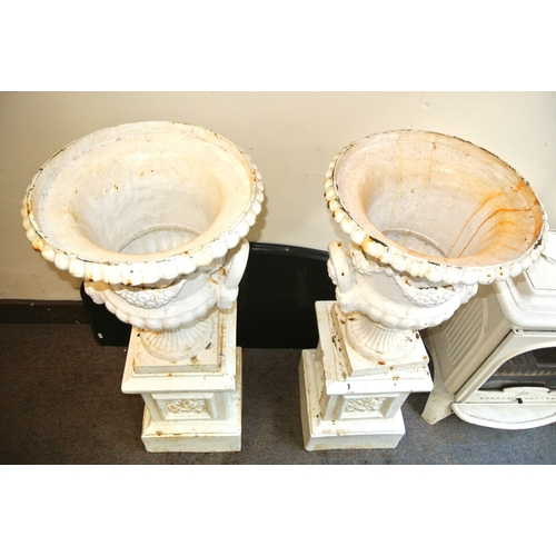 207 - Pair of Victorian style cast iron campana shaped garden vases with grape vine & reeded decoration, o... 