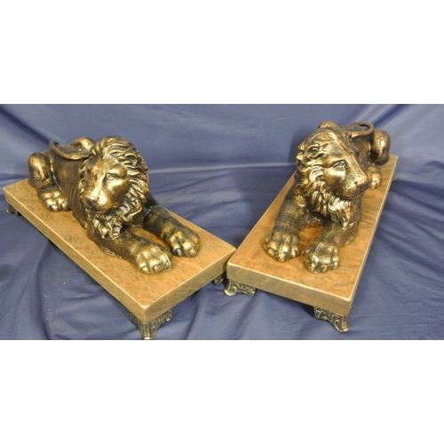 247 - Pair of ornate gilded reclining lions on oblong timber plinths with shaped legs