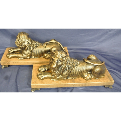 247 - Pair of ornate gilded reclining lions on oblong timber plinths with shaped legs