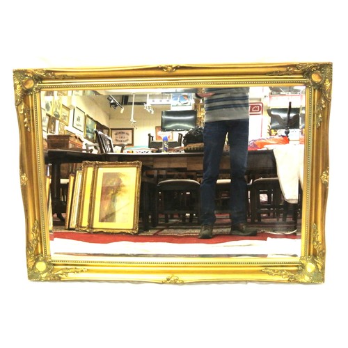 122 - Regency design oblong bevelled wall mirror with ornate foliate decoration 106 x76cm